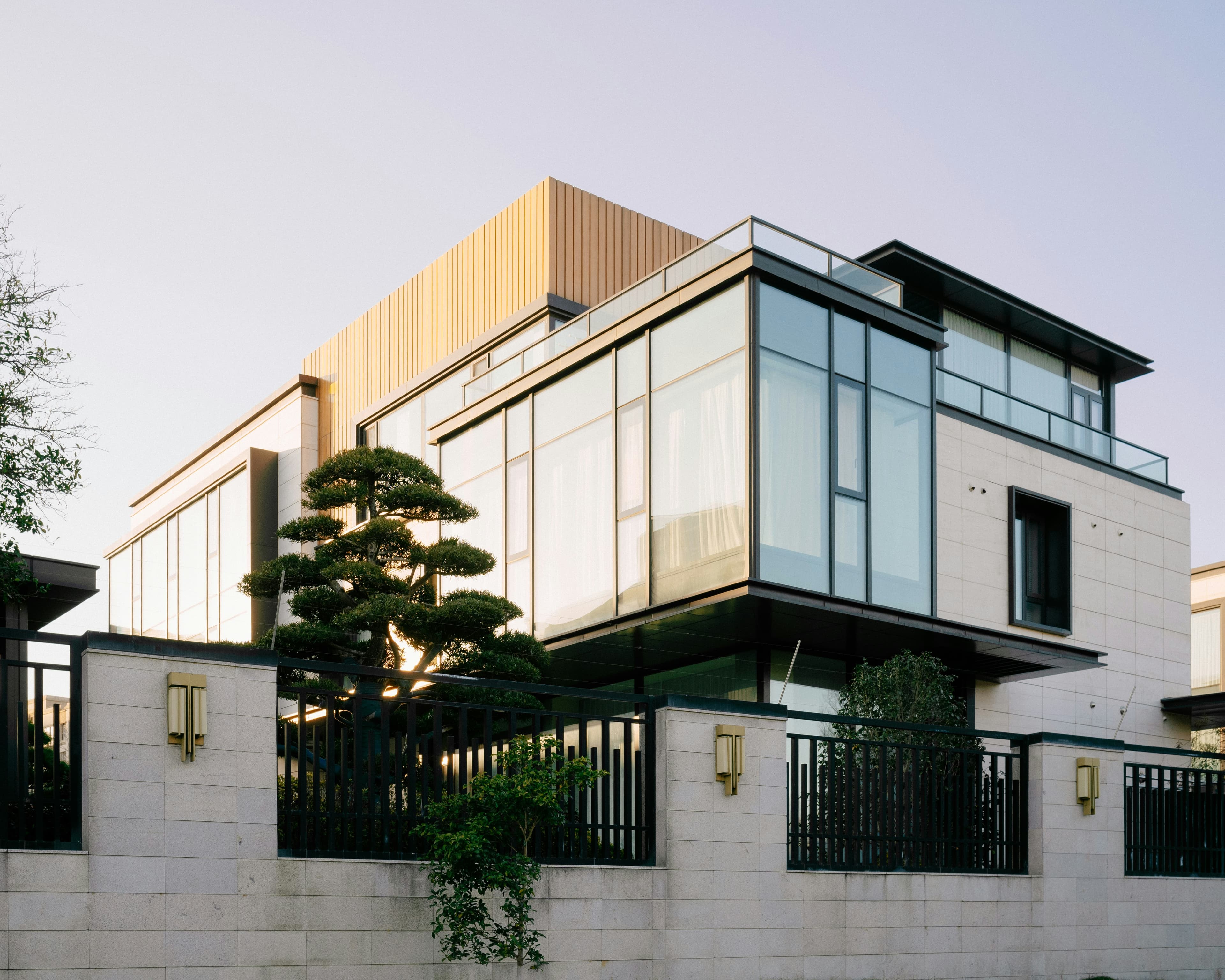 Modern glazed house behind a tree